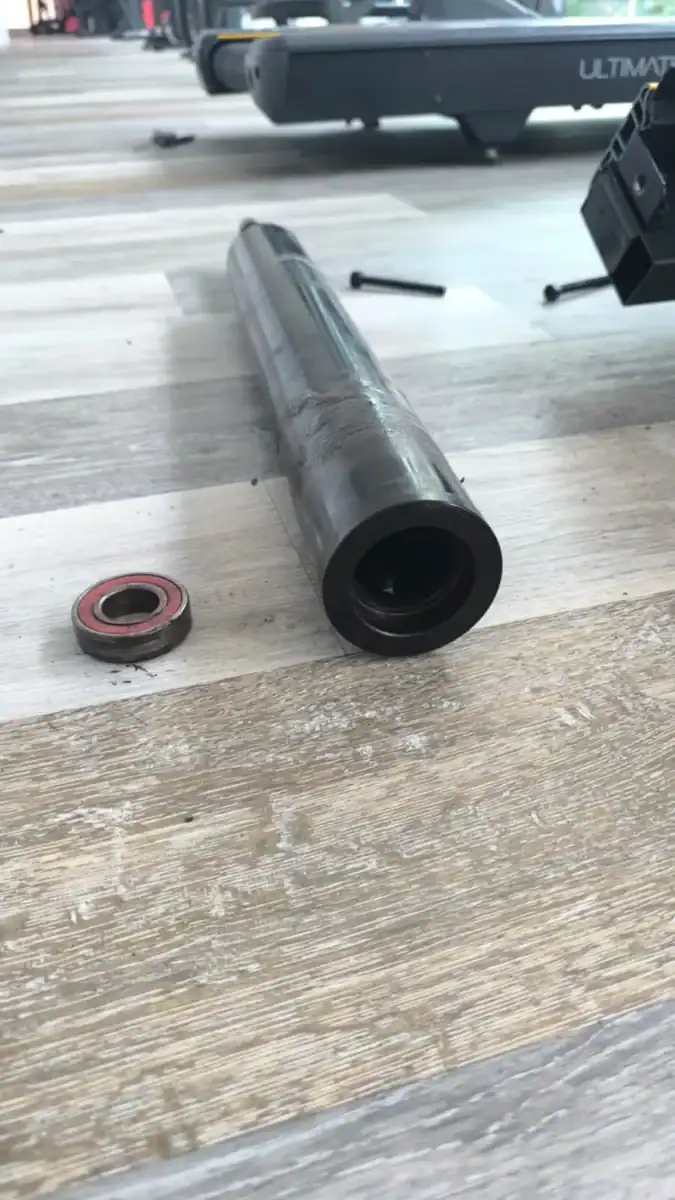 Ausgebaute Laufbandrolle mit defektem Lager einer Fitness-Laufbandmaschine
