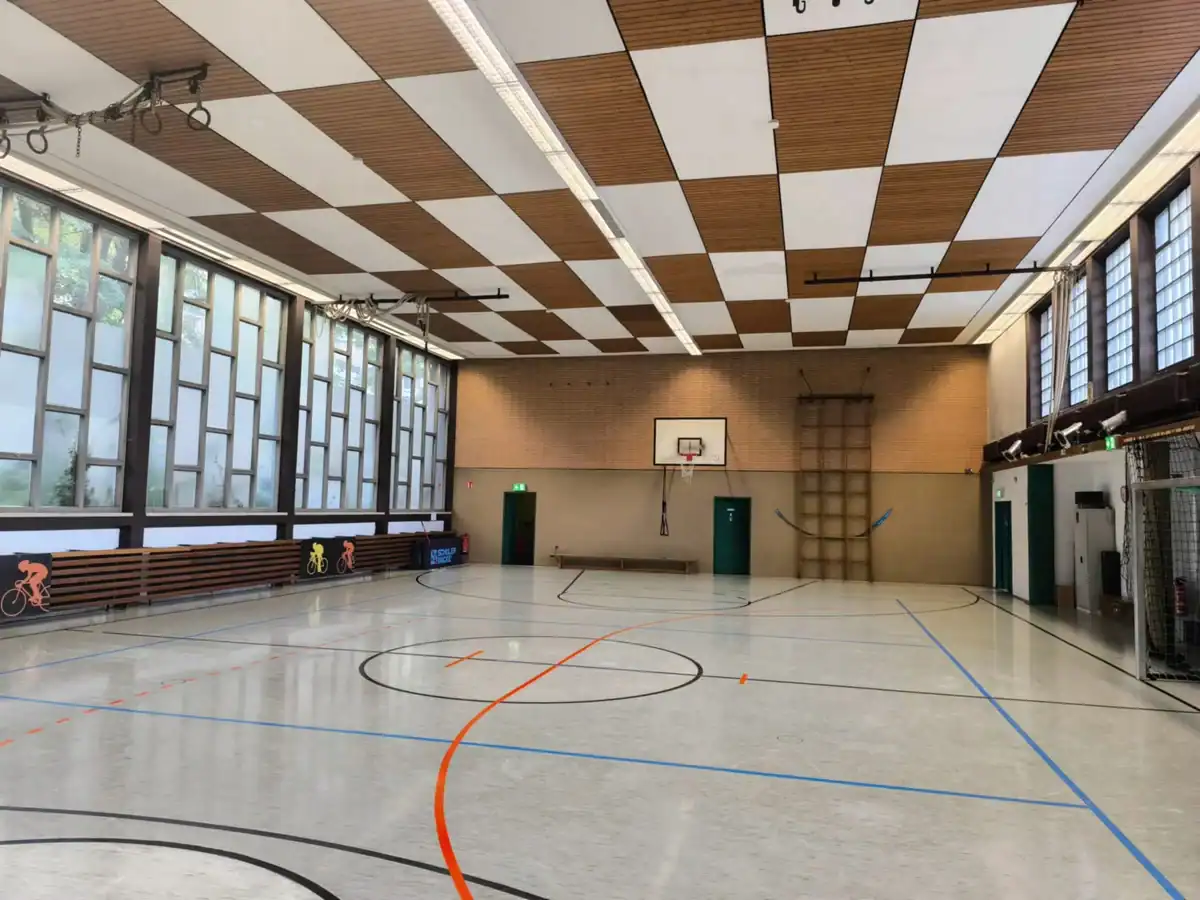 Sporthalle mit Basketballkorb und Spielfeldmarkierungen – DGUV-Prüfung